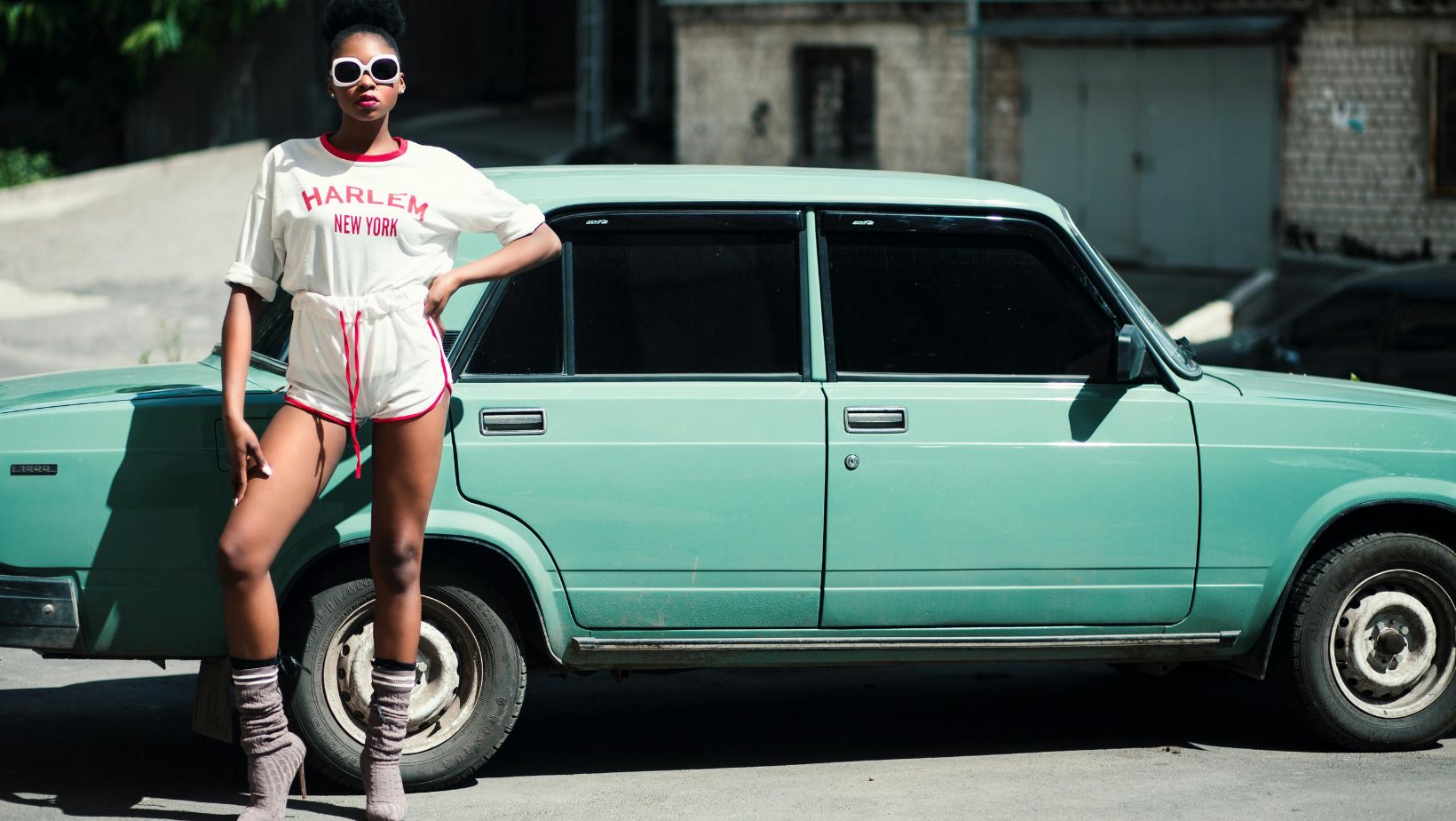 Woman posing in front of a vintage car.