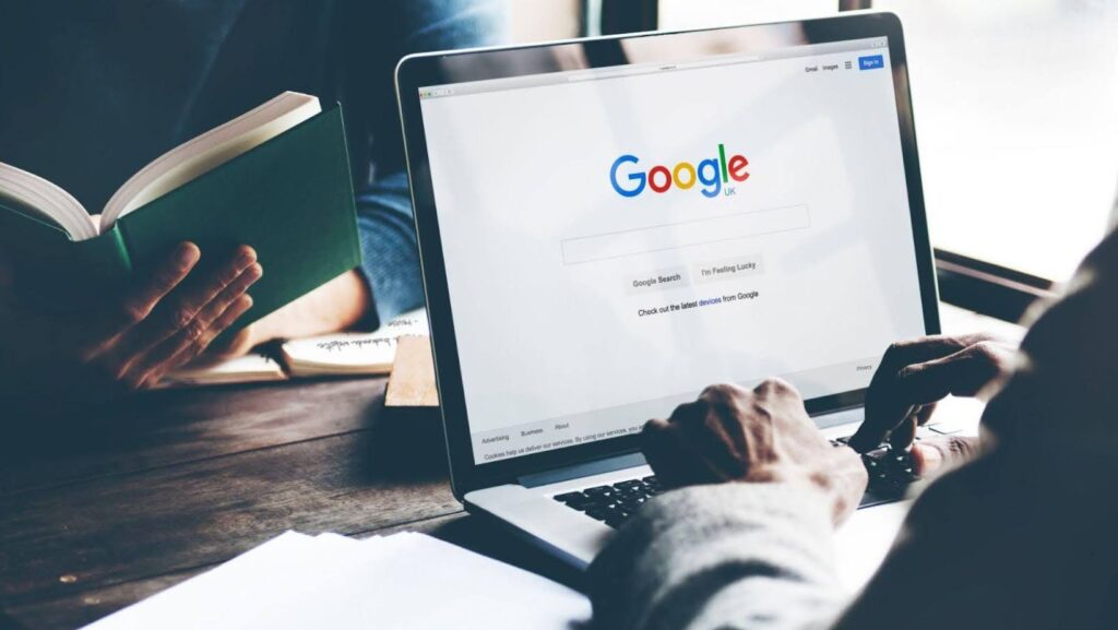 Person using a laptop with Google search open on the screen while doing a background check on someone.